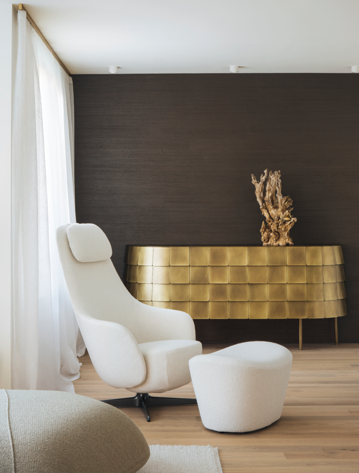 Timeless elegance paired with the masterful art of furniture design: the "Harbor Laidback" armchair and stool from B&B Italia and the "Yoroi" sideboard from de Castelli