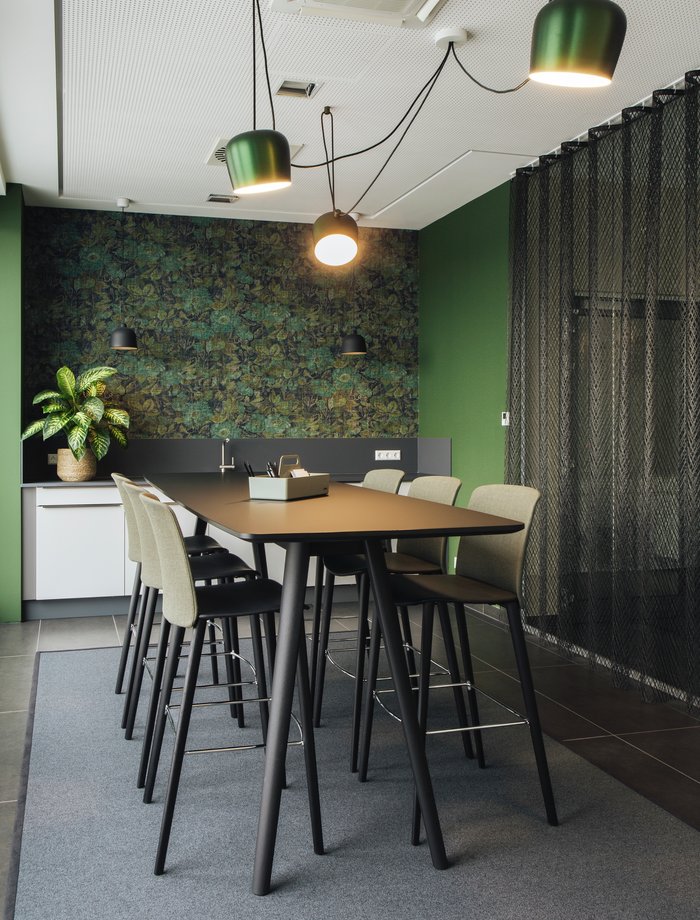 For the coffee break: the kitchen area with bar tables from Walter Knoll, bar stools from Arper and lights from Flos.